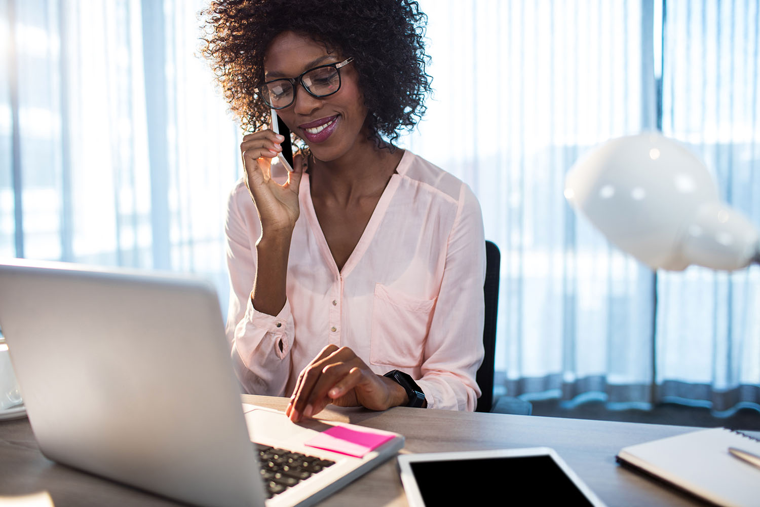 woman on phone looking at computer